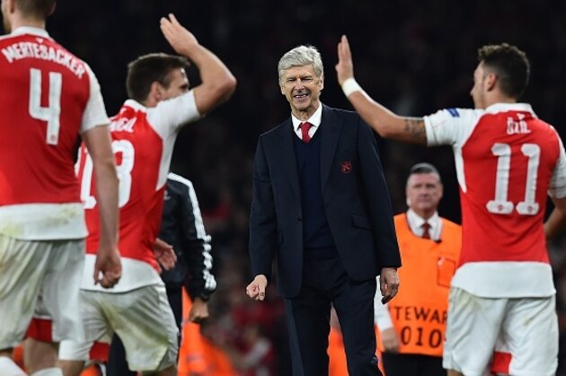 Arsenal's French manager Arsene Wenger (C) watches as Arsenal's German midfielder Mesut Ozil (R) celebrates scoring his team's second goal with teamamte Arsenal's Spanish defender Nacho Monreal during the UEFA Champions League football match between Arsenal and Bayern Munich at the Emirates Stadium in London, on October 20, 2015.  Arsenal won the match 2-0.  AFP PHOTO / BEN STANSALL        (Photo credit should read BEN STANSALL/AFP/Getty Images)