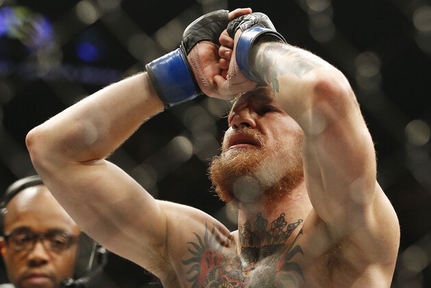 Conor McGregor celebrates after defeating Chad Mendes in their interim featherweight title mixed martial arts bout at UFC 189 Saturday, July 11, 2015, in Las Vegas. (AP Photo/John Locher)