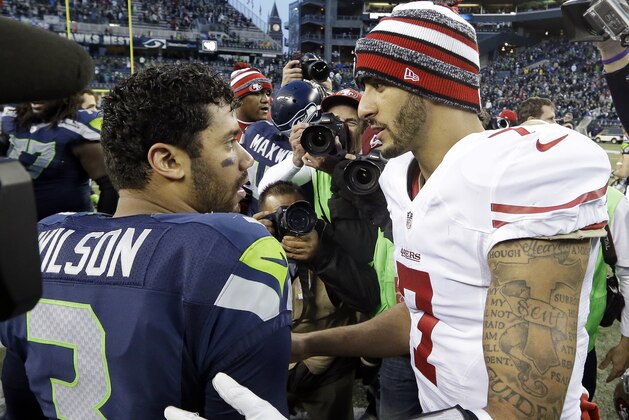 Seattle Seahawks quarterback Russell Wilson (3) and San Francisco 49ers quarterback Colin Kaepernick meet after an NFL football game, Sunday, Dec. 14, 2014, in Seattle. The Seahawks won 17-7. (AP Photo/Elaine Thompson)