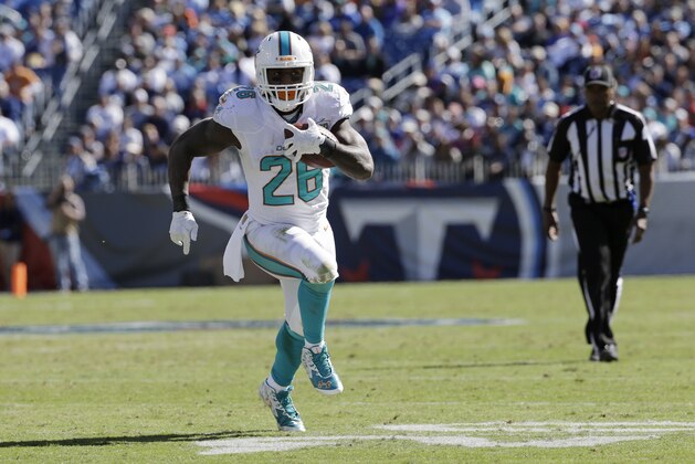 Miami Dolphins running back Lamar Miller runs the ball against the Tennessee Titans in the first half of an NFL football game Sunday, Oct. 18, 2015, in Nashville, Tenn. (AP Photo/James Kenney)