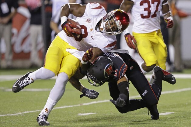 Southern California wide receiver JuJu Smith (9) takes a hit from Utah defensive back Davion Orphey (11) before scoring in the first quarter during an NCAA college football game Saturday, Oct. 25, 2014, in Salt Lake City. (AP Photo/Rick Bowmer)