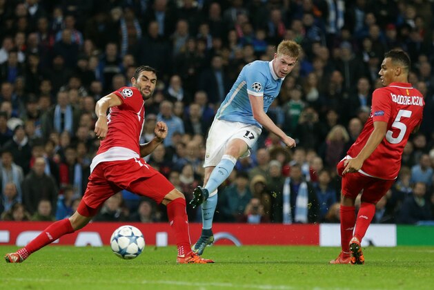 Manchester City's Kevin De Bruyne, centre,  shoots and score his sides second goal during the Champions League Group D soccer match between Manchester City and Sevilla at the Etihad Stadium, Manchester, England, Wednesday, Oct. 21, 2015. (AP Photo/Clint Hughes)