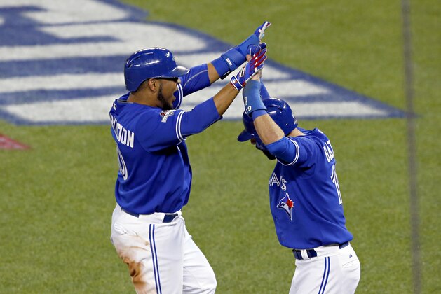 Toronto Blue Jays' Edwin Encarnacion, left, and Jose Bautista celebrates Troy Tulowitzki's three run double against the Kansas City Royals during the sixth inning in Game 5 of baseball's American League Championship Series on Wednesday, Oct. 21, 2015, in Toronto. (AP Photo/Paul Sancya)