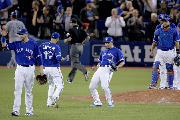 Toronto Blue Jays relief pitcher Roberto Osuna, middle, celebrates their 7-1 win against the Kansas City Royals in Game 5 of baseball's American League Championship Series on Wednesday, Oct. 21, 2015, in Toronto. (AP Photo/Charlie Riedel)