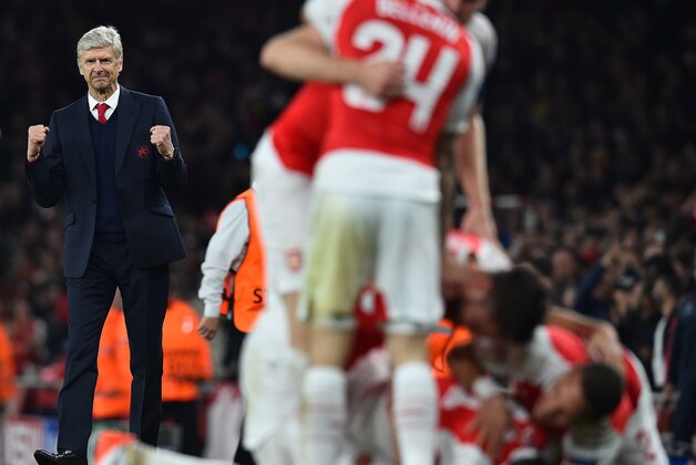 Arsenal's French manager Arsene Wenger (L) watches as his players celebrate Arsenal's German midfielder Mesut Ozil's goal during the UEFA Champions League football match between Arsenal and Bayern Munich at the Emirates Stadium in London, on October 20, 2015.  Arsenal won the match 2-0.  AFP PHOTO / BEN STANSALL        (Photo credit should read BEN STANSALL/AFP/Getty Images)