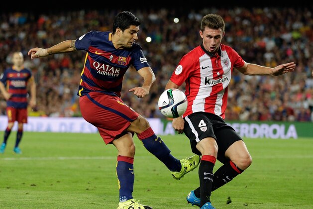 Athletic Bilbao's Aymeric Laporte, right, blocks a shot from Barcelona's Luis Suarez during a second leg Spanish Super Cup soccer match between FC Barcelona and Athletic Bilbao at the Camp Nou stadium in Barcelona, Spain, Monday, Aug.17, 2015. (AP Photo/Manu Fernandez)