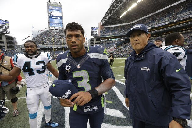 Seattle Seahawks quarterback Russell Wilson, center, walks off the field after an an NFL football game against the Carolina Panthers, Sunday, Oct. 18, 2015, in Seattle. The Panthers beat the Seahawks 27-23. (AP Photo/Elaine Thompson)