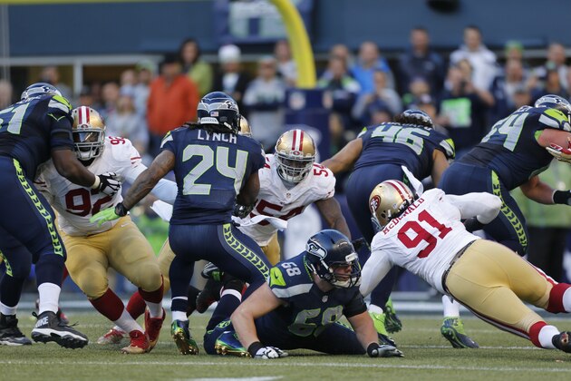 SEATTLE, WA - DECEMBER 14: Quinton Dial #92, Nick Moody #54 and Ray McDonald #91 of the San Francisco 49ers corral Marshawn Lynch #24 of the Seattle Seahawks during the game at  CenturyLink Field on December 14, 2014 in Seattle, Washington. The Seahawks defeated the 49ers 17-7. (Photo by Michael Zagaris/San Francisco 49ers/Getty Images)