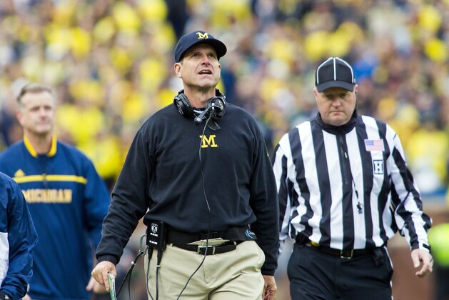 Michigan head coach Jim Harbaugh looks up at the scoreboard on the sidelines in the second quarter of an NCAA college football game against Michigan State in Ann Arbor, Mich., Saturday, Oct. 17, 2015. (AP Photo/Tony Ding)