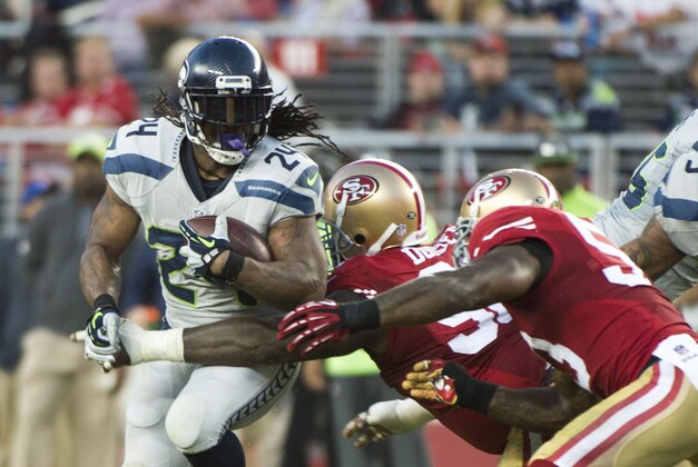 October 22, 2015; Santa Clara, CA, USA; Seattle Seahawks running back Marshawn Lynch (24) runs against San Francisco 49ers defensive end Glenn Dorsey (center) and inside linebacker NaVorro Bowman (right) during the second quarter at Levi's Stadium. Mandatory Credit: Kyle Terada-USA TODAY Sports