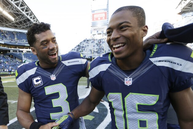 Seattle Seahawks quarterback Russell Wilson, left, greets wide receiver Tyler Lockett, right, after the Seahawks beat the Chicago Bears 26-0 in the second half of an NFL football game, Sunday, Sept. 27, 2015, in Seattle. (AP Photo/John Froschauer)