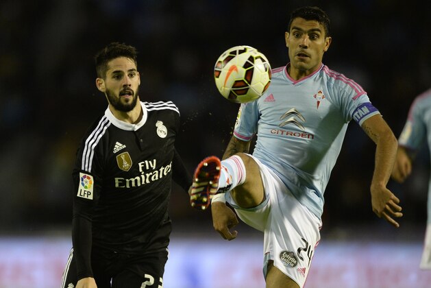 Real Madrid's midfielder Isco (L) vies with Celta's Argentinian midfielder Augusto Fernandez during the Spanish league football match Celta Vigo vs  Real Madrid CF at the Balaidos stadium in Vigo on April 26, 2015.  AFP PHOTO/ MIGUEL RIOPA        (Photo credit should read MIGUEL RIOPA/AFP/Getty Images)