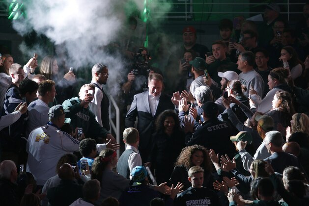 Michigan State coach Tom Izzo, center, makes an entrance through the crowd before an NCAA college basketball scrimmage, Friday, Oct. 23, 2015, in East Lansing, Mich. (AP Photo/Al Goldis)