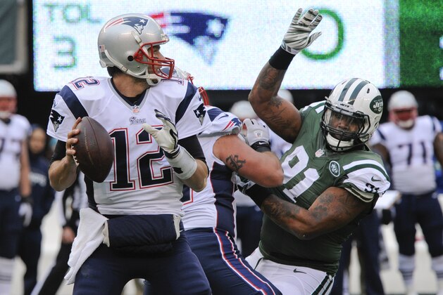 New England Patriots quarterback Tom Brady (12) looks to pass as New York Jets' Sheldon Richardson (91) rushes him during the first half of an NFL football game Sunday, Dec. 21, 2014, in East Rutherford, N.J. (AP Photo/Bill Kostroun)