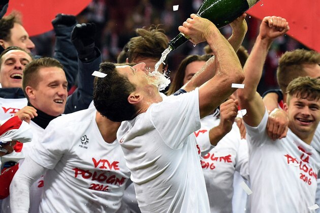 Poland's forward and captain Robert Lewandowski (C) drinks champagne as teammates celebrate the qualification with jersey reading 'Vive la Pologne 2016 ' after the Euro 2016 Group D qualifying football match between Poland and the Republic of Ireland at the Stadion Narodowy in Warsaw on October 11, 2015.   AFP PHOTO / JANEK SKARZYNSKI        (Photo credit should read JANEK SKARZYNSKI/AFP/Getty Images)