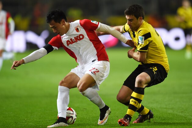 Augsburg's South Korean forward Dong-Won Ji (L) and Dortmund's Greek defender Sokratis vie for the ball during the German first division Bundesliga football match Borussia Dortmund vs FC Augsburg in the Signal Iduna Park stadium in Dortmund, western Germany on February 4, 2015. AFP PHOTO / PATRIK STOLLARZ

DFL RULES TO LIMIT THE ONLINE USAGE DURING MATCH TIME TO 15 PICTURES PER MATCH. IMAGE SEQUENCES TO SIMULATE VIDEO IS NOT ALLOWED AT ANY TIME. FOR FURTHER QUERIES PLEASE CONTACT DFL DIRECTLY AT + 49 69 650050.        (Photo credit should read PATRIK STOLLARZ/AFP/Getty Images)