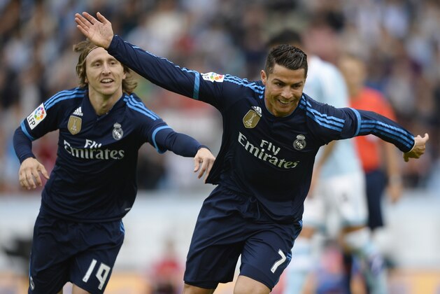 Real Madrid's Portuguese forward Cristiano Ronaldo (R) celebrates with teammate Croatian midfielder Luka Modric after scoring a goal during the Spanish league football match Celta Vigo vs Real Madrid CF at the Balaidos stadium in Vigo on October 24, 2015.  AFP PHOTO / MIGUEL RIOPA        (Photo credit should read MIGUEL RIOPA/AFP/Getty Images)