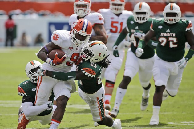 Clemson running back Wayne Gallman (9) is tackled by Miami linebacker Jermaine Grace (5) and defensive back Dallas Crawford (25) during the first half of an NCAA College football game, Saturday, Oct. 24, 2015 in Miami Gardens, Fla. (AP Photo/Wilfredo Lee)