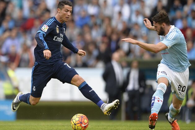 Real Madrid's Portuguese forward Cristiano Ronaldo (L) vies with Celta Vigo's defender Sergi Gomez during the Spanish league football match Celta Vigo vs Real Madrid CF at the Balaidos stadium in Vigo on October 24, 2015.  AFP PHOTO / MIGUEL RIOPA        (Photo credit should read MIGUEL RIOPA/AFP/Getty Images)