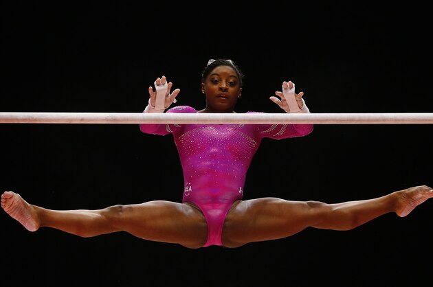Simone Biles of the U.S. performs on the uneven bars as she takes part in the women's qualification competition at the World Artistic Gymnastics championships in Glasgow, Scotland, Saturday, Oct. 24, 2015. (AP Photo/Matthias Schrader)
