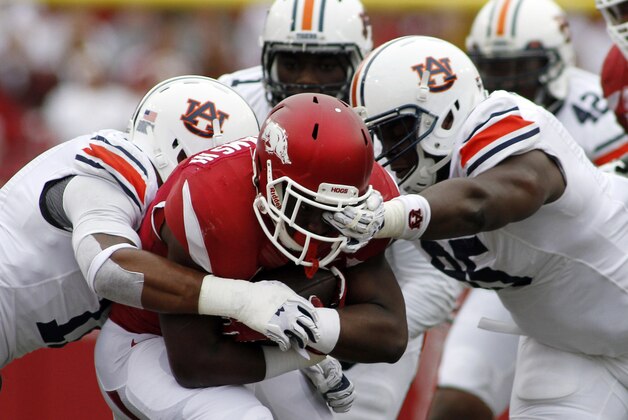 Arkansas' Rawleigh Williams III, center,  attempts to break through the grip of the Auburn's defense during an NCAA college football game Saturday, Oct. 24, 2015, in Fayetteville, Ark. (AP Photo/Samantha Baker)