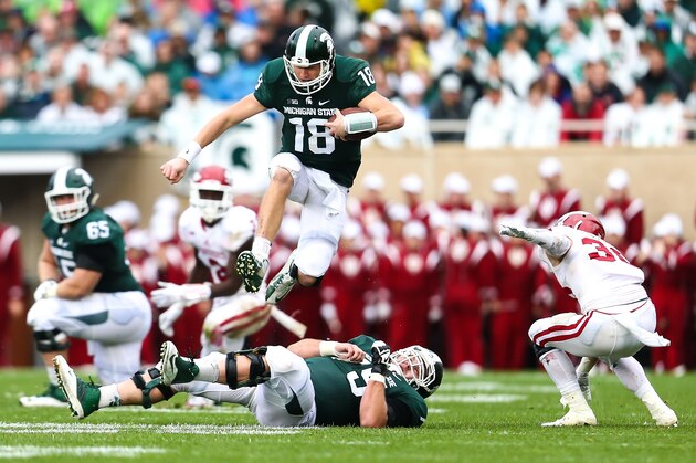 EAST LANSING, MI - OCTOBER 24: Connor Cook #18 of the Michigan State Spartans jumps over Benny McGowan #75 of the Michigan State Spartans for the first down in the second quarter against the Indiana Hoosiers at Spartan Stadium on October 24, 2015 in East Lansing, Michigan. (Photo by Rey Del Rio/Getty Images) EAST LANSING, MI - OCTOBER 24: Connor Cook #18 of the Michigan State Spartans jumps over Benny McGowan #75 of the Michigan State Spartans for the first down in the second quarter against the Indiana Hoosiers at Spartan Stadium on October 24, 2015 in East Lansing, Michigan. (Photo by Rey Del Rio/Getty Images)