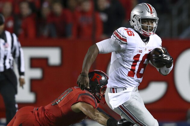 Ohio State quarterback J.T. Barrett (16) breaks a tackle by Rutgers defensive back Anthony Cioffi (31) during the first half of an NCAA college football game Saturday, Oct. 24, 2015, in Piscataway, N.J. (AP Photo/Mel Evans)