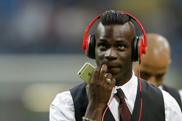AC Milan's Mario Balotelli wears earphones prior to the start of a Serie A soccer match between Inter Milan and AC Milan, at the San Siro stadium in Milan, Italy, Sunday, Sept. 13, 2015. (AP Photo/Luca Bruno)