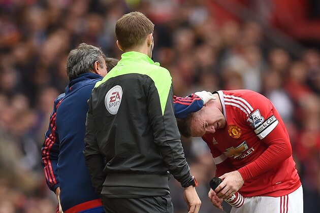 Manchester United's English striker Wayne Rooney (R) is treated for a head injury during the English Premier League football match between Manchester United and Manchester City at Old Trafford in Manchester, north west England, on October 25, 2015.  AFP PHOTO / PAUL ELLIS

RESTRICTED TO EDITORIAL USE. No use with unauthorized audio, video, data, fixture lists, club/league logos or 'live' services. Online in-match use limited to 75 images, no video emulation. No use in betting, games or single club/league/player publications.        (Photo credit should read PAUL ELLIS/AFP/Getty Images)