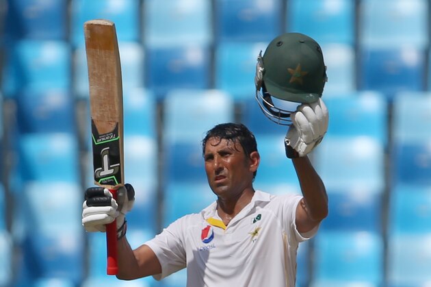 Pakistan's Younis Khan salutes fans after reaching a century (100 runs) during the fourth day of the second Test cricket match between Pakistan and England in Dubai on October 25, 2015. AFP PHOTO / MARWAN NAAMANI        (Photo credit should read MARWAN NAAMANI/AFP/Getty Images)