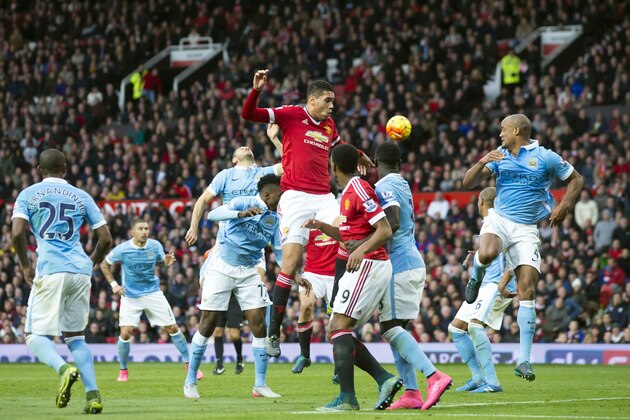 Manchester United's Chris Smalling, centre, challenges for the ball during the English Premier League soccer match between Manchester United and Manchester City at Old Trafford Stadium, Manchester, England, Sunday, Oct. 25, 2015. (AP Photo/Jon Super)