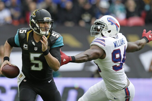 Jacksonville Jaguars quarterback Blake Bortles (5) alludes the challenge of Buffalo Bills defensive end Mario Williams (94)during the NFL game between Buffalo Bills and Jacksonville Jaguars at Wembley Stadium in London,  Sunday, Oct. 25, 2015. (AP Photo/Tim Ireland)