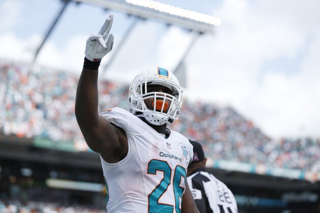 Miami Dolphins running back Lamar Miller (26) raises his hand after scoring a touchdown during the first half of an NFL football game against the Houston Texans, Sunday, Oct. 25, 2015 in Miami Gardens, Fla. (AP Photo/Joel Auerbach)