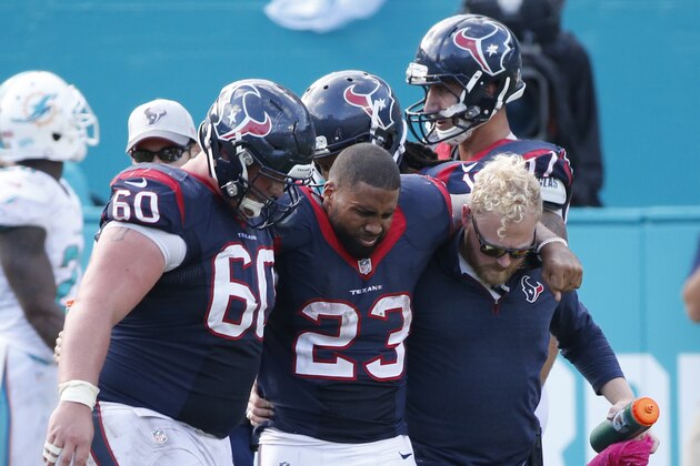 Houston Texans running back Arian Foster (23) is helped off the field by center Ben Jones (60) and an unidentified team member, during the second half of an NFL football game against the Miami Dolphins, Sunday, Oct. 25, 2015 in Miami Gardens, Fla. The Dolphins defeated the Texans 44-26. (AP Photo/Wilfredo Lee)