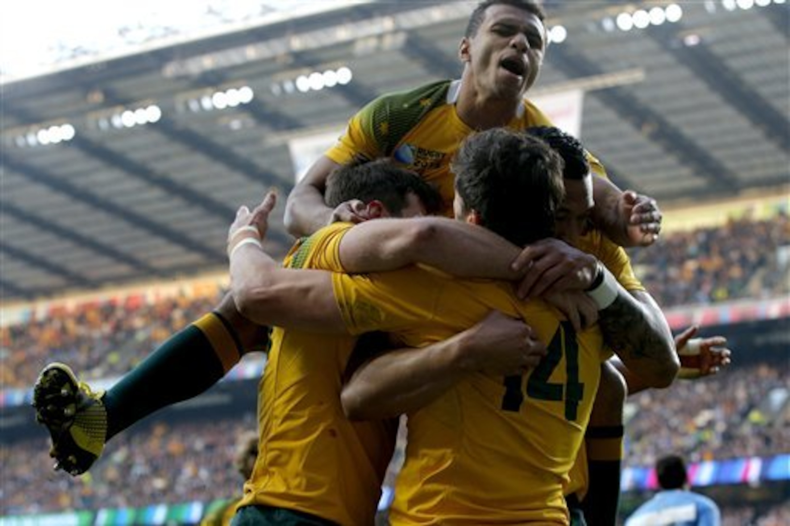 Australia's Will Genia, top, leaps on teammate Adam Ashley-Cooper, right, after scoring a try during their Rugby World Cup semifinal match against Argentina at Twickenham Stadium, London, Sunday, Oct. 25, 2015. (AP Photo/Christophe Ena)