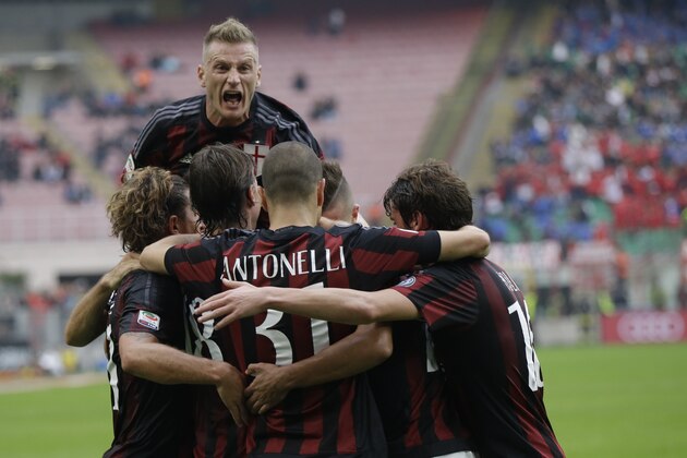 AC Milan 's Ignazio Abate jumps over his teammates in celebration after Carlos Bacca scored the opening goal during a Serie A soccer match between AC Milan and Sassuolo, at the San Siro stadium in Milan, Italy, Sunday, Oct. 25, 2015. (AP Photo/Luca Bruno)