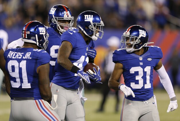 New York Giants cornerback Dominique Rodgers-Cromartie, center,  celebrates with teammates Trevin Wade, right, and Robert Ayers, left, after intercepting a pass during the second half of an NFL football game against the Dallas Cowboys Sunday, Oct. 25, 2015, in East Rutherford, N.J. (AP Photo/Seth Wenig)