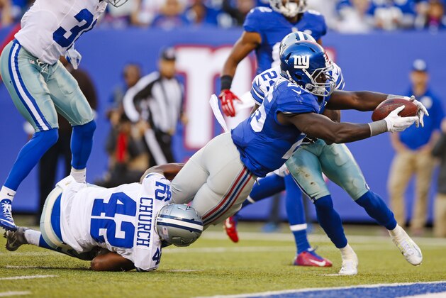 New York Giants running back Orleans Darkwa (26) dives past Dallas Cowboys' Barry Church (42) for a touchdown as Byron Jones (31) chases them during the first half of an NFL football game, Sunday, Oct. 25, 2015, in East Rutherford, N.J. (AP Photo/Kathy Willens)