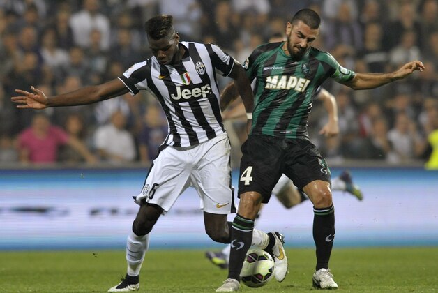 Sassuolo's Francesco Magnanelli, right, vies for the ball with Juventus's Paul Pogba, during their Serie A soccer match at Reggio Emilia's Mapei stadium, Italy, Saturday, Oct. 18, 2014. (AP Photo/Marco Vasini)