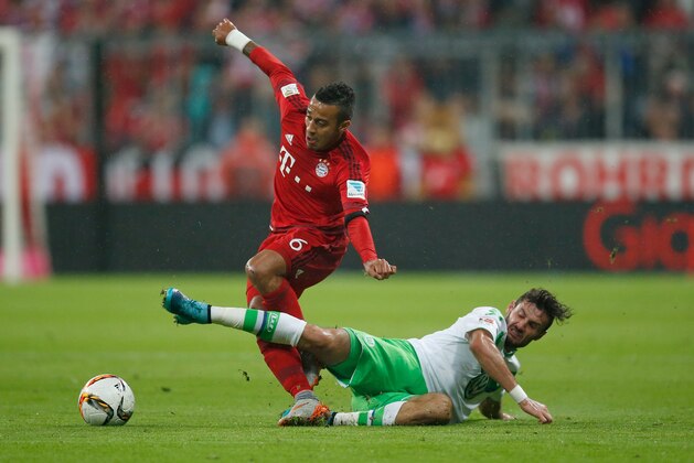 MUNICH, GERMANY - SEPTEMBER 22:  Thiago Alcantara (L) of Muenchen is tackled by Daniel Caligiuri of Wolfsburg during the Bundesliga match between FC Bayern Muenchen and VfL Wolfsburg at Allianz Arena on September 22, 2015 in Munich, Germany.  (Photo by Boris Streubel/Getty Images)