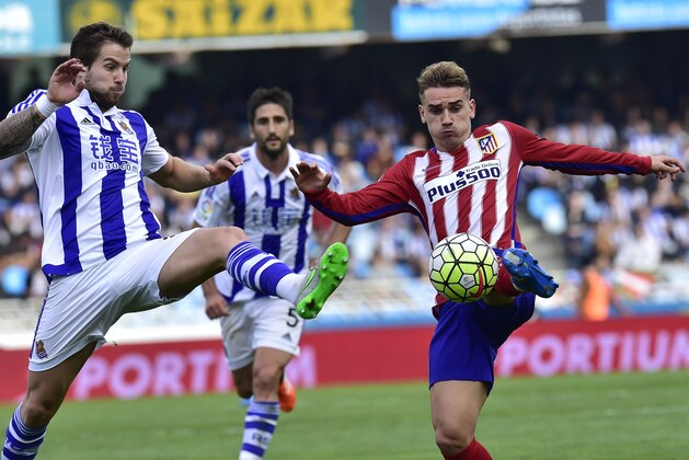 Atletico de Madrid's Antoine Griezmann, right,  duels for the ball with Real Sociedad's Inigo Martinez, during their Spanish La Liga soccer match, at Anoeta stadium in San Sebastian, northern Spain, Sunday, Oct. 18, 2015. (AP Photo/Alvaro Barrientos)