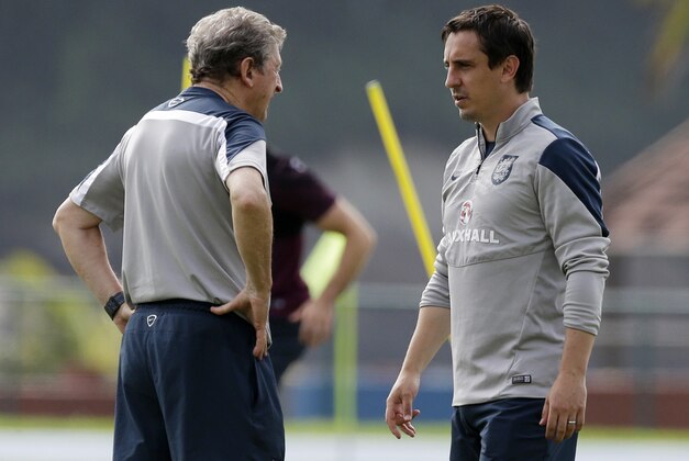England national soccer team head coach Roy Hodgson, left, talks with coach Gary Neville during a squad training session for the 2014 soccer World Cup at the Urca military base in Rio de Janeiro, Brazil, Saturday, June 21, 2014.  Costa Rica's surprise 1-0 win over Italy on Friday meant that England made its most humiliating exit from a World Cup since 1958, following consecutive defeats by the Italians and then Uruguay in Group D.  England play Costa Rica in their final Group D match on Tuesday.  (AP Photo/Matt Dunham)