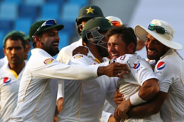 Pakistan's cricket players celebrate after they dismissed England's Adil Rashid to win the second Test cricket match between Pakistan and England in the Gulf emirate of Dubai on October 26, 2015. AFP PHOTO / MARWAN NAAMANI        (Photo credit should read MARWAN NAAMANI/AFP/Getty Images)