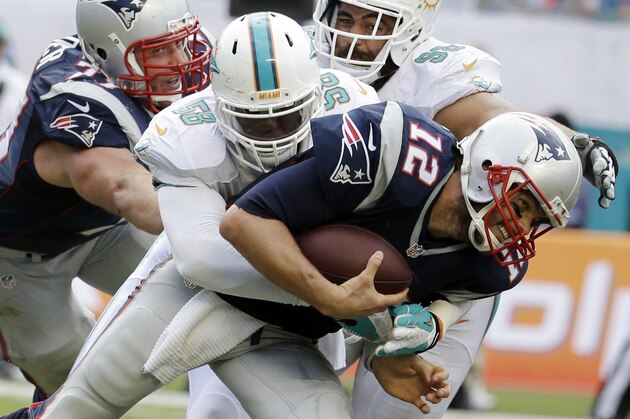 New England Patriots quarterback Tom Brady (12) is sacked by Miami Dolphins linebacker Chris McCain (58), during the second half of an NFL football game, in Miami Gardens, Fla., Sunday Sept. 7, 2014. (AP Photo/Lynne Sladky)