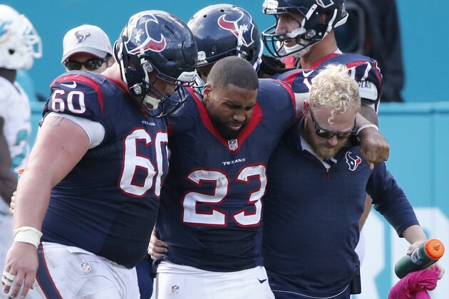 Houston Texans running back Arian Foster (23) struggles to walk as he is helped off the field by center Ben Jones (60) and an unidentified team member, during the second half of an NFL football game against the Miami Dolphins, Sunday, Oct. 25, 2015 in Miami Gardens, Fla. The Dolphins defeated the Texans 44-26. (AP Photo/Wilfredo Lee)