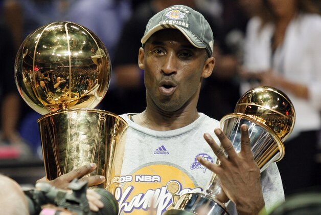 FILE - This is a June 14, 2009, file photo showing Los Angeles Lakers' Kobe Bryant holding the Larry O'Brien championship trophy and finals MVP trophy after the Lakers beat the Orlando Magic 99-86 in Game 5 of the NBA basketball finals, in Orlando, Fla. Bryant was on top when the decade started, and he still is when it ends. Someone so good deserves to be considered among the candidates for The Associated Press' Athlete of the Decade.(AP Photo/David J. Phillip, File)