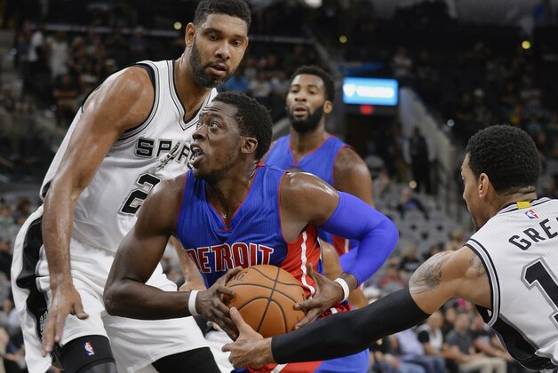 Detroit Pistons guard Reggie Jackson, center, prepares to shoot against San Antonio Spurs forward Tim Duncan, left, and Spurs guard Danny Green during the first half of a preseason NBA basketball game, Sunday, Oct. 18, 2015, in San Antonio. (AP Photo/Darren Abate)