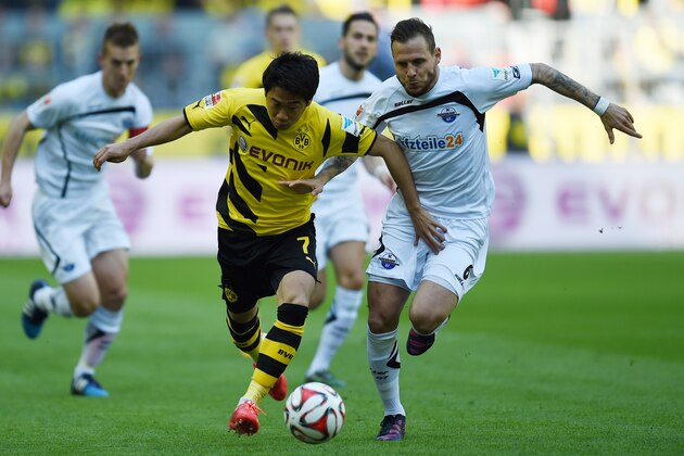 Dortmund's Japanese midfielder Shinji Kagawa (L) and Paderborn's midfielder Marvin Bakalorz vie for the ball during the German first division Bundesliga football match Borussia Dortmund vs SC Paderborn in Dortmund, western Germany, on April 18, 2015. AFP PHOTO / PATRIK STOLLARZ

RESTRICTIONS - DFL RULES TO LIMIT THE ONLINE USAGE DURING MATCH TIME TO 15 PICTURES PER MATCH. IMAGE SEQUENCES TO SIMULATE VIDEO IS NOT ALLOWED AT ANY TIME. FOR FURTHER QUERIES PLEASE CONTACT DFL DIRECTLY AT + 49 69 650050.        (Photo credit should read PATRIK STOLLARZ/AFP/Getty Images)