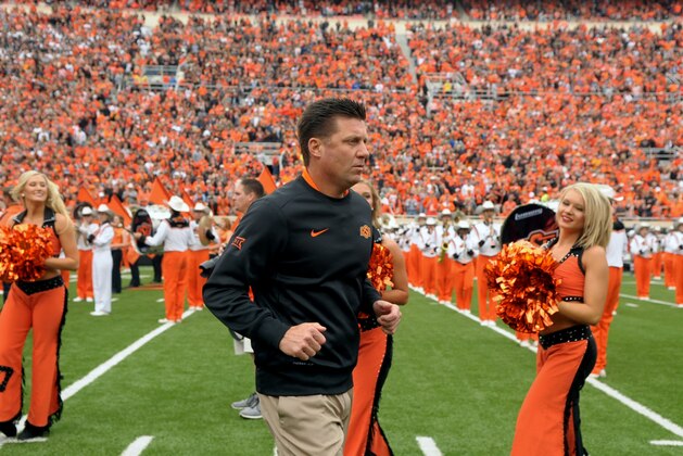 Oklahoma State head coach Mike Gundy jogs onto the field at the start of an NCAA college football game between Kansas and Oklahoma St in Stillwater, Okla., Saturday, Oct. 24, 2015.(AP Photo/Brody Schmidt)