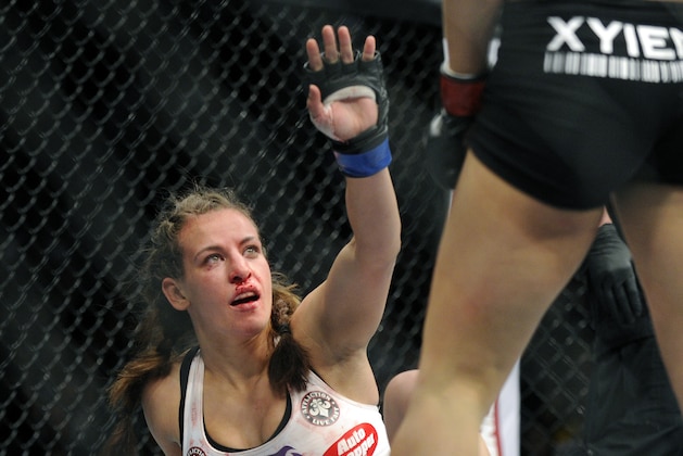Miesha Tate of Yakima, Wash., gestures to Ronda Rousey of Venice, Calif., during the UFC 168 mixed martial arts middleweight championship bout during the UFC 168 mixed martial arts women's bantamweight title fight on Saturday, Dec. 28, 2013, in Las Vegas. Rousey won by a third round tap out. (AP Photo/David Becker)